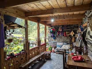 A cozy wooden veranda in a Georgian village, decorated with colorful handicrafts.